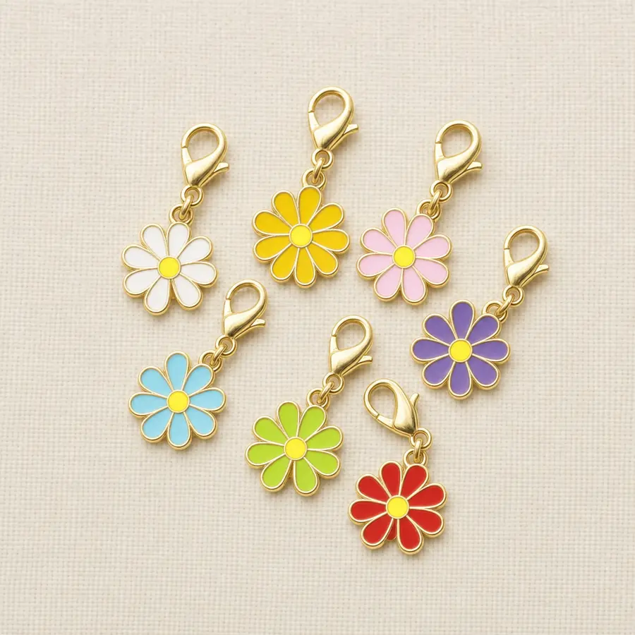 Seven daisy enamel charm stitch markers with gold clasps on warm cream linen